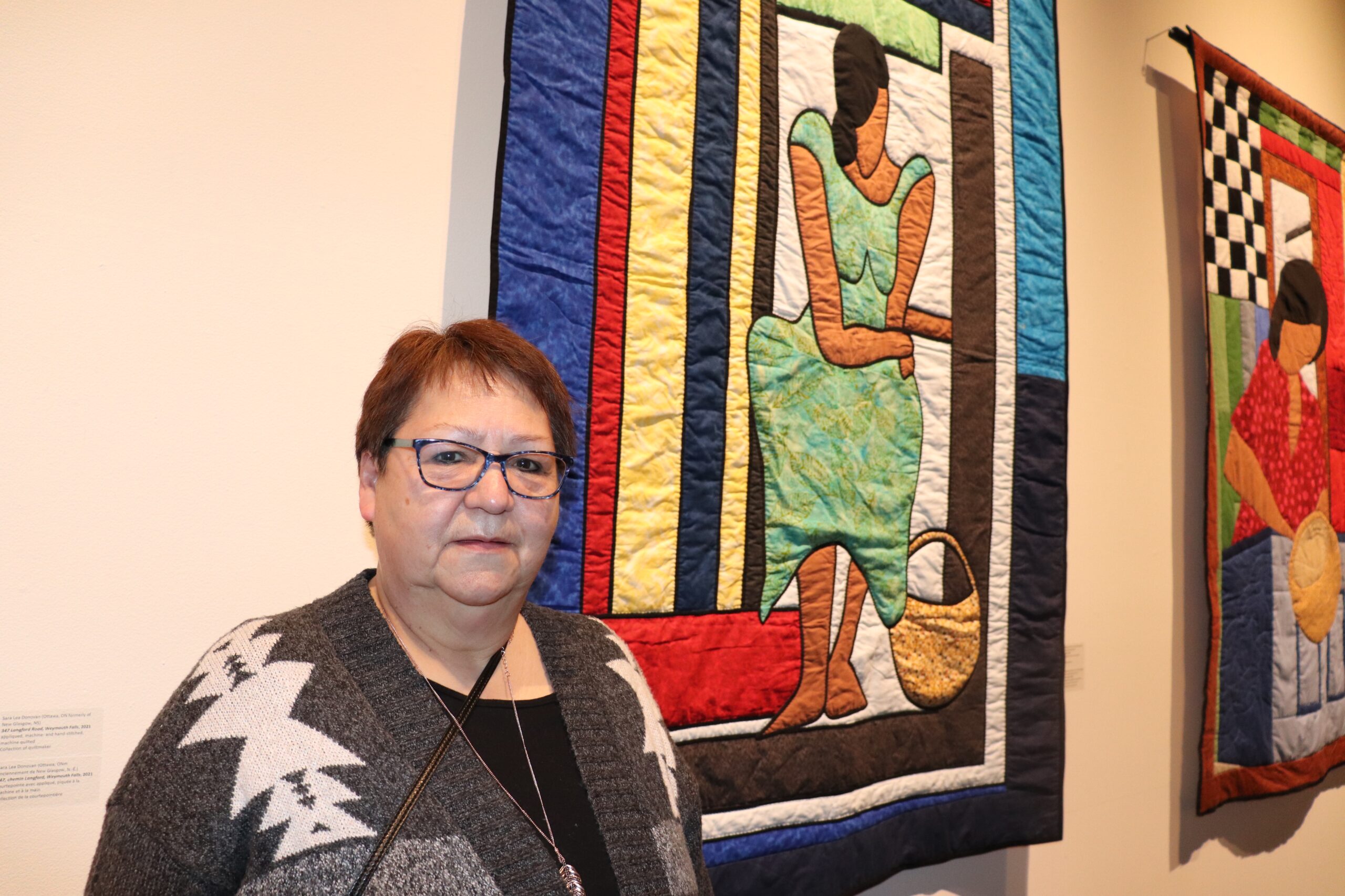 第一民族女士在非洲新斯科舍被子前摆姿势