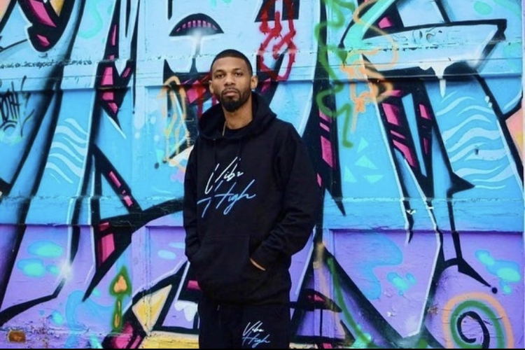 身穿黑色卫衣的黑人男子在涂鸦壁画前摆姿势