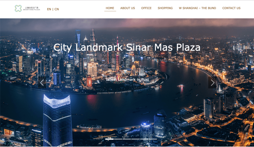 这张截图显示了中国上海金光广场的网站截图，称其为“城市地标”，显示了该地区夜间照片中巨大的塔楼和五彩缤纷的灯光。该大厦属于金光置业(Sinar Mas Land)，是威德嘉家族金光集团(Sinar Mas Group)的子公司。