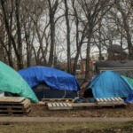在滴水下的三个帐篷在秋天的湿日