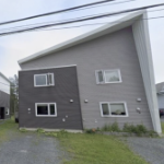 一栋新房子，有三种深浅的灰色，斜檐向上向右突出。