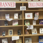 书架上有几本书和写着“禁止”和“挑战”的牌子。