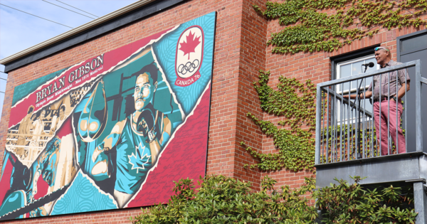 一幅男子拳击的壁画展示在一座红砖建筑的一侧