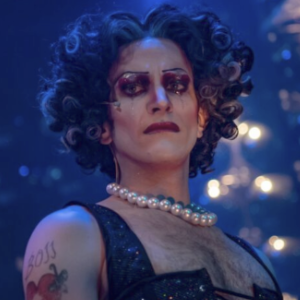 An actor in a corset, pearls, and garish makeup in a local production of Rocky Horror Show