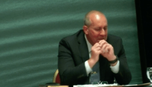 一名男子坐在桌子旁，在大规模伤亡委员会作证