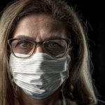 一位中年妇女，一头深金色头发，戴着面具