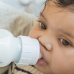 一个黑色的婴儿从瓶子里满意