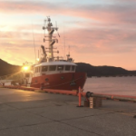 A boat at a pier at sunset