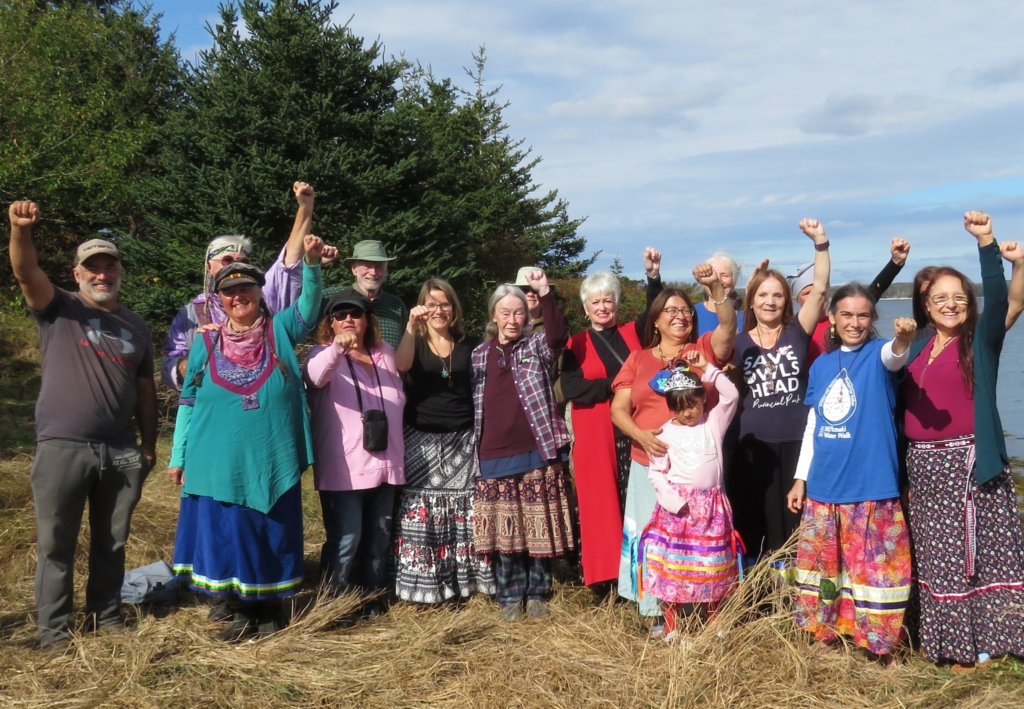 A group of women dressed in traditional Mi'kmaw attire celebrate at a gathering.