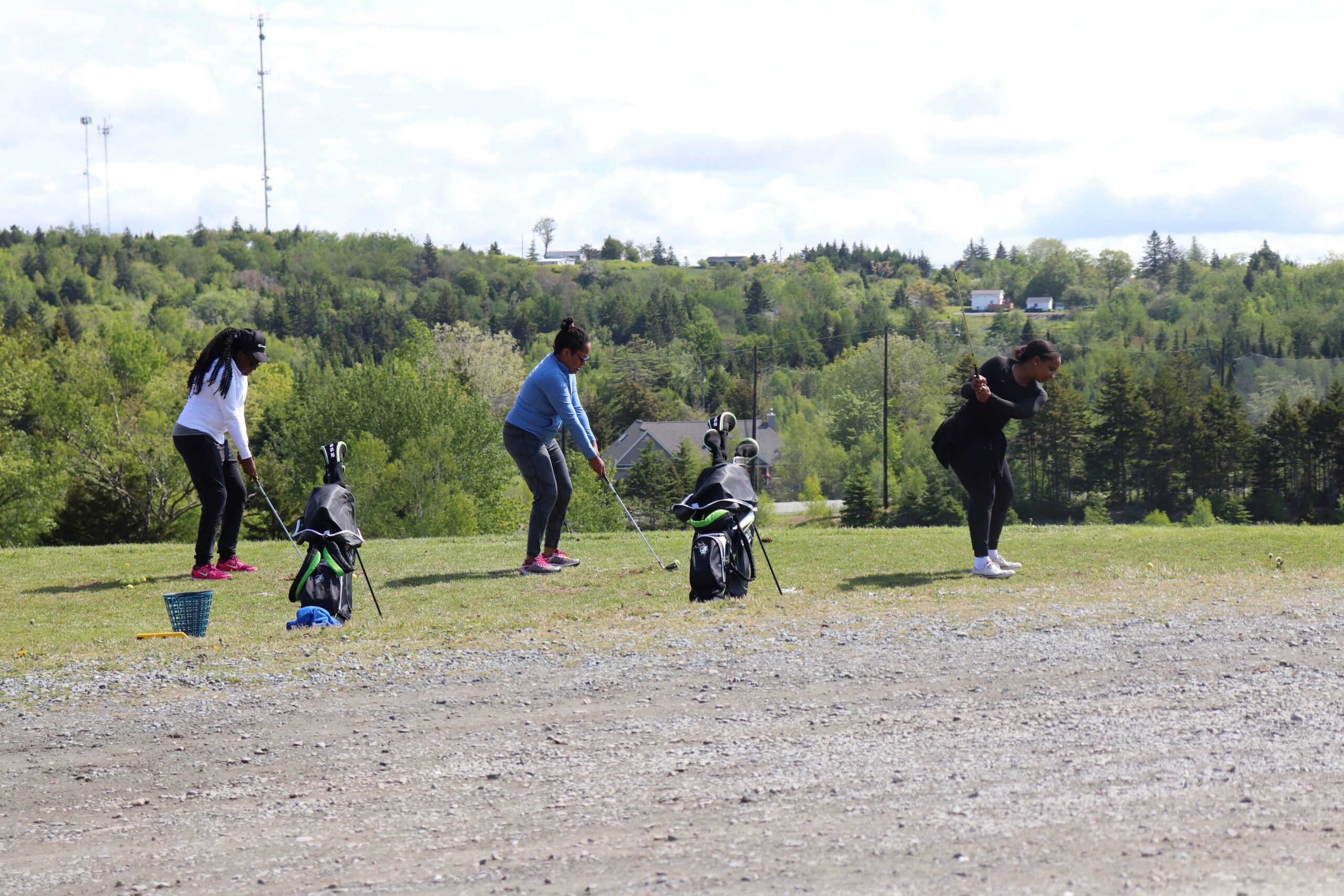Three Black women on the golf driving range