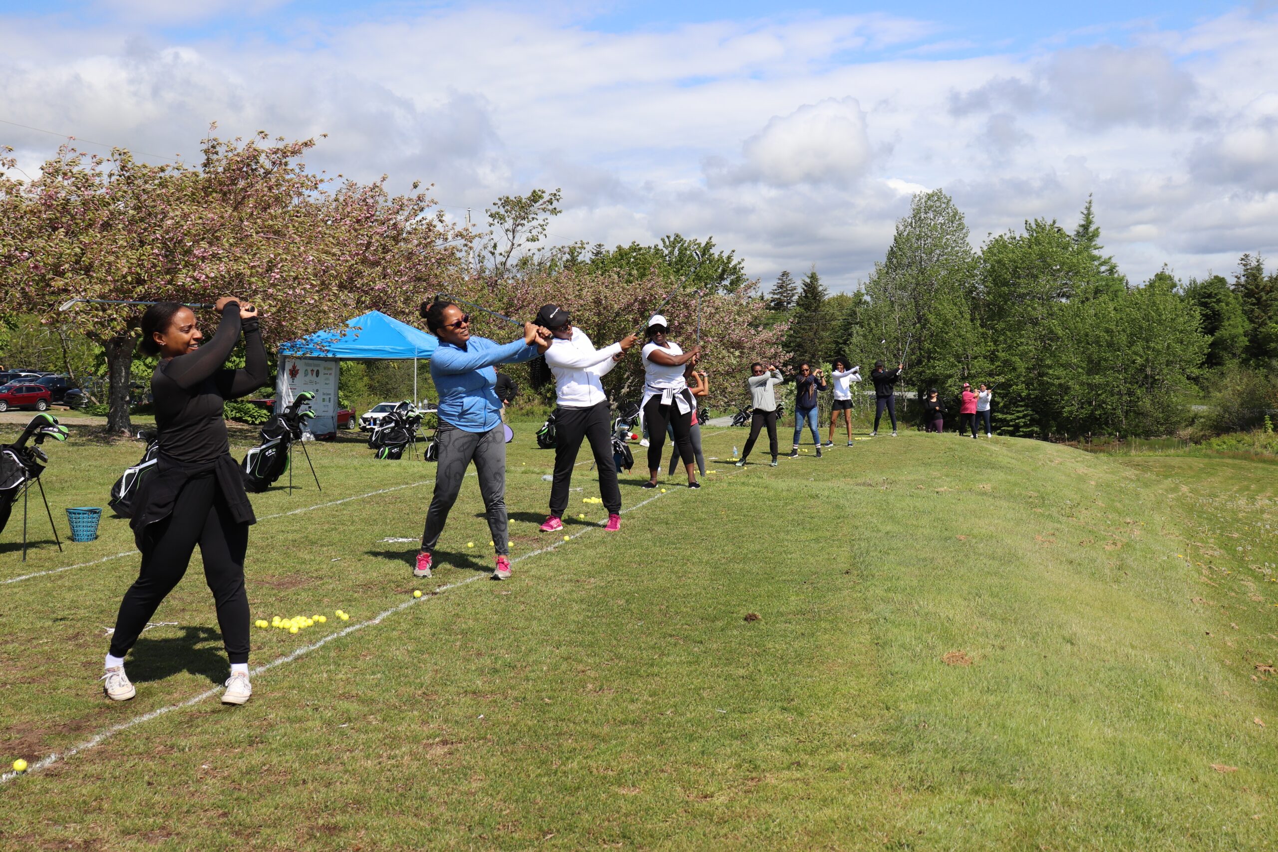 一系列黑人妇女在练习场上跟随他们的高尔夫挥杆