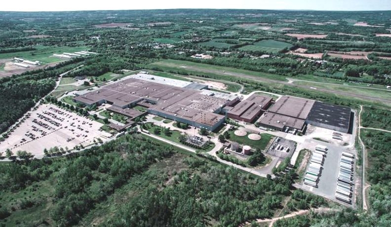位于沃特维尔的米其林工厂鸟瞰图。这是一个大型建筑群，有一个停车场，周围都是树木和农场。