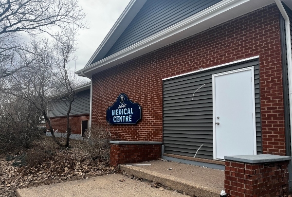 A red brick building with a white door and a sign that says medical centre