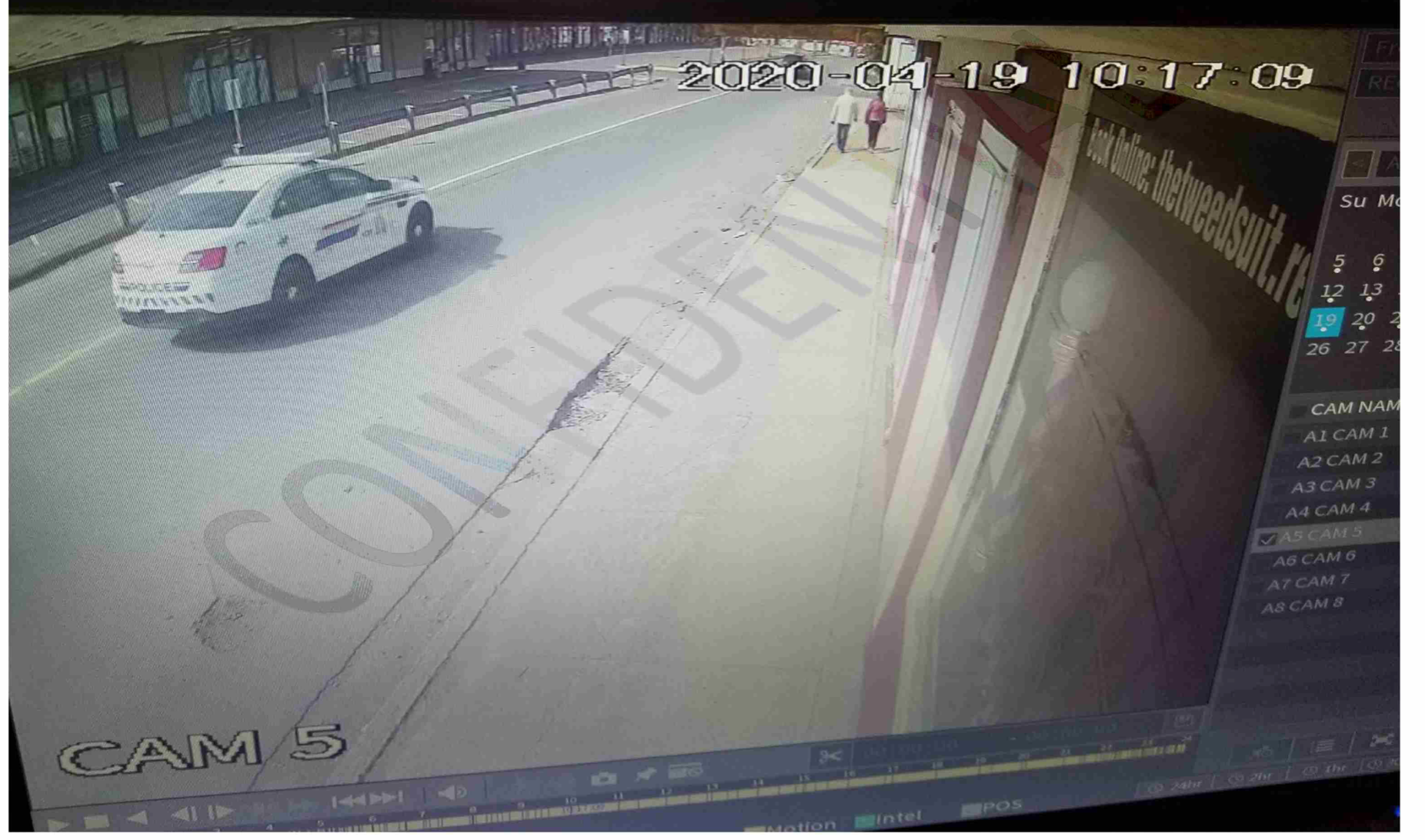 a screenshot from a video of a fake police car driving past two pedestrians