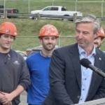 蒂姆·休斯顿与戴着安全帽的人交谈