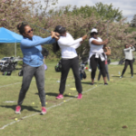 一排黑人妇女在练习她们的高尔夫挥杆