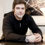 A young white man wearing a black hoodie and a rolex