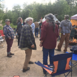A group of protesters chat happily in a cleared area in a forest