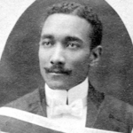 一张黑白照片，一个留着小胡子、打着白色领结的黑人