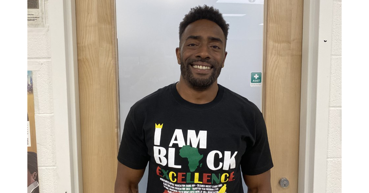 一名身穿“我是优秀黑人”t恤的黑人对着镜头微笑。