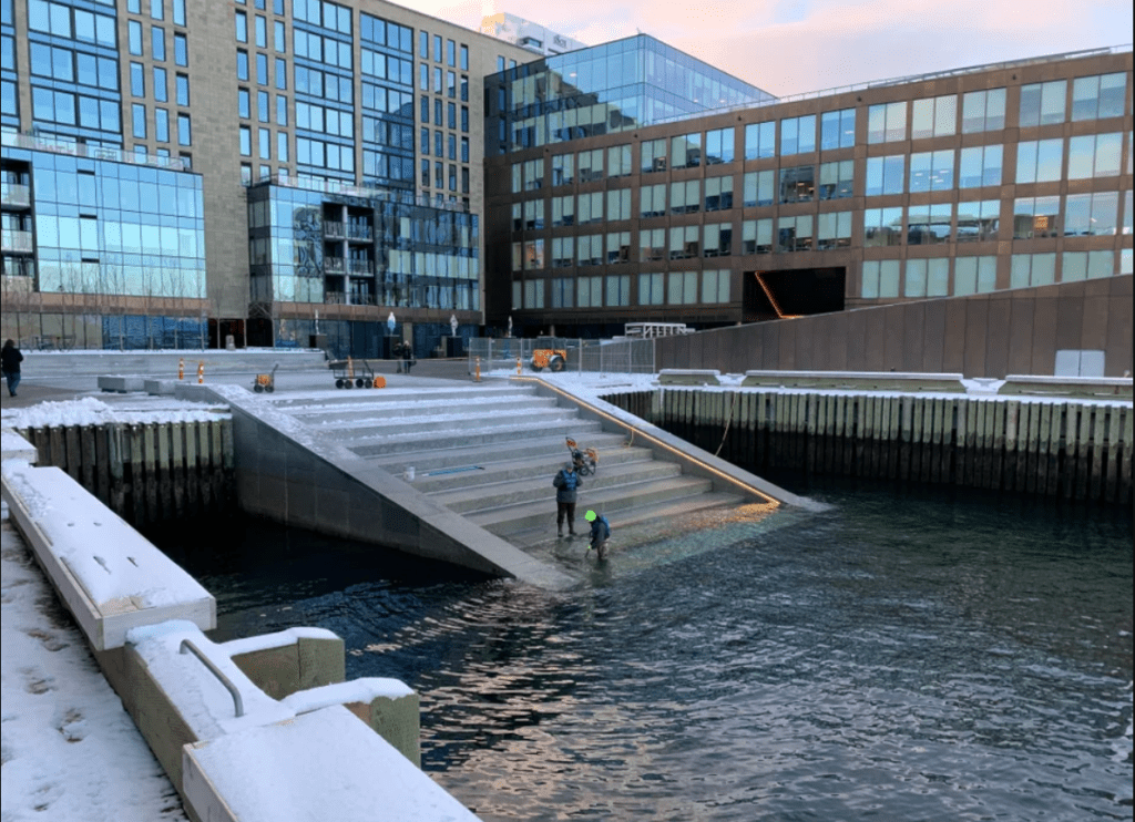 People standing on the stairs in the harbour cleaning them.