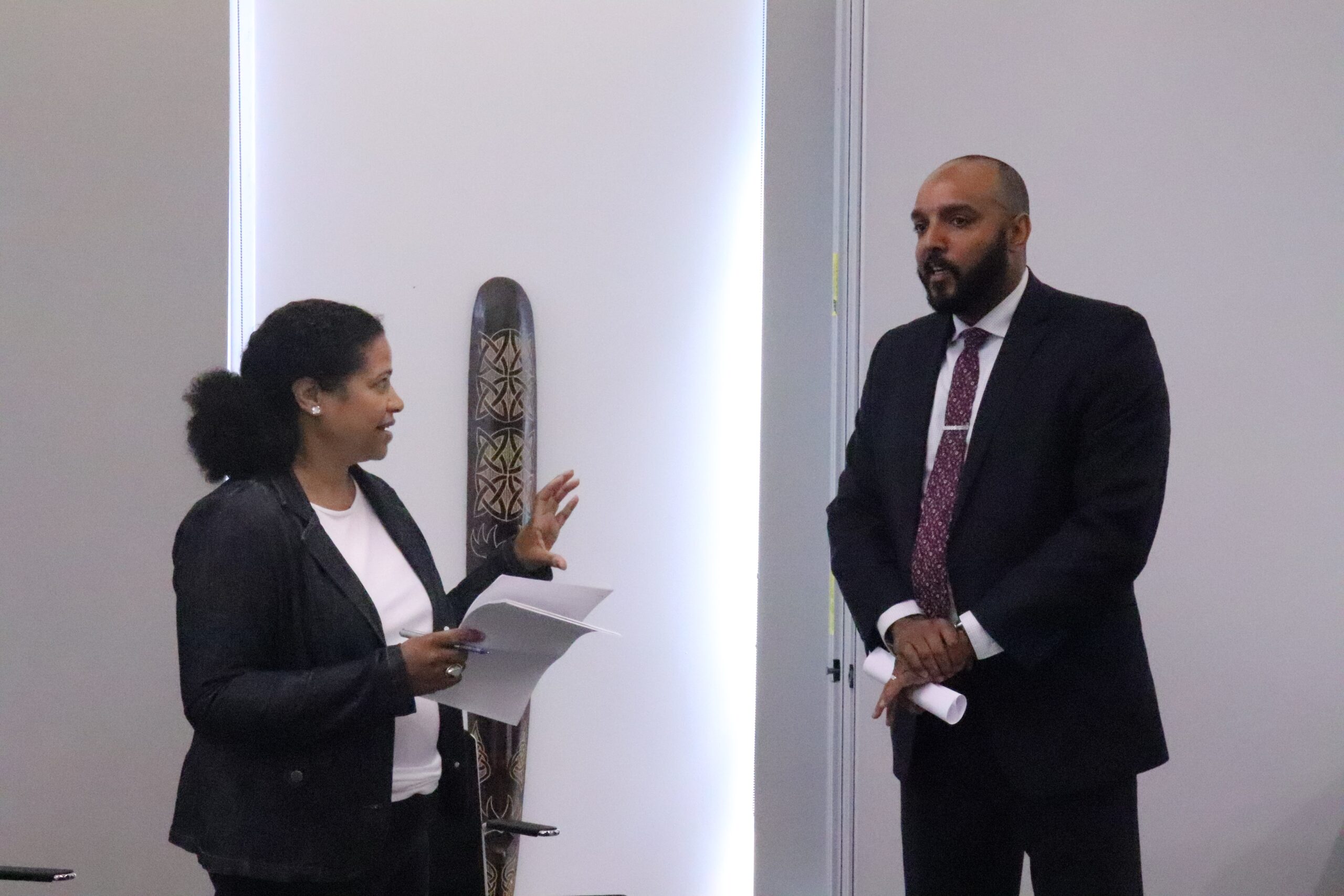 A man and a woman stand facing each other and talking.