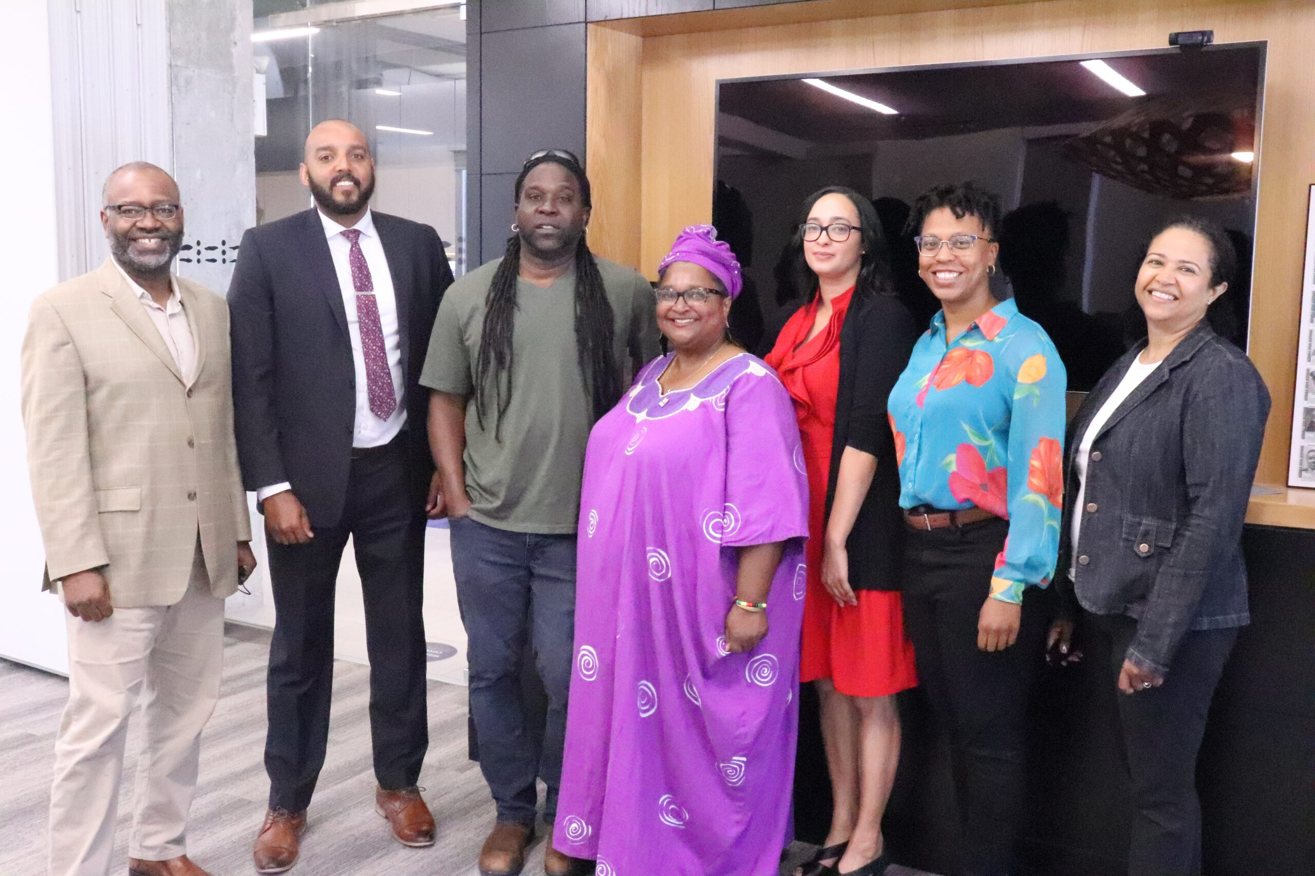 A group of seven people standing and smiling at the camera.