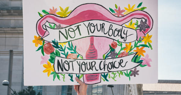 A hand holding a sign that reads 