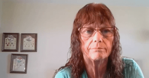 通过视频连接的一名妇女从家中看着摄像头