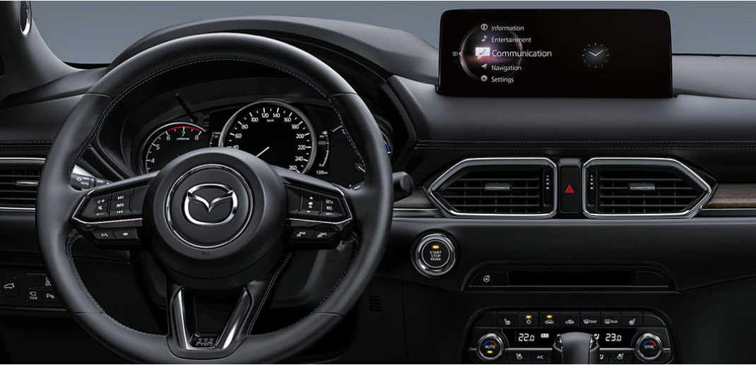 一辆汽车的方向盘，可见信息娱乐屏幕