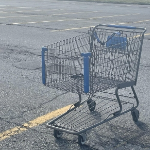 一辆孤零零的购物车停在空荡荡的停车场里