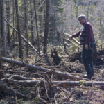 一个白人男子站在森林的空地上