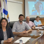 四个白人，两女两男，坐在一排桌子旁