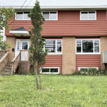 一栋两层并排的双层公寓，有红色墙板