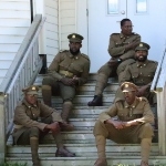 一群人穿着20世纪初的仿制制服坐在教堂的台阶上