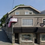 一栋两层楼的建筑，米黄色的壁板，侧面有一组牙齿