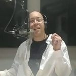 一个男人坐在录音室的麦克风前