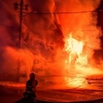 一名消防员站在着火的建筑物前