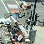 一名工人坐在卡车上的水桶里取下路灯杆上的标识