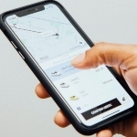 一名男子手持屏幕上显示优步应用程序的iPhone