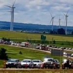 2020年夏天，在新斯科舍省和新不伦瑞克省边境的一系列汽车。背景是风力涡轮机。