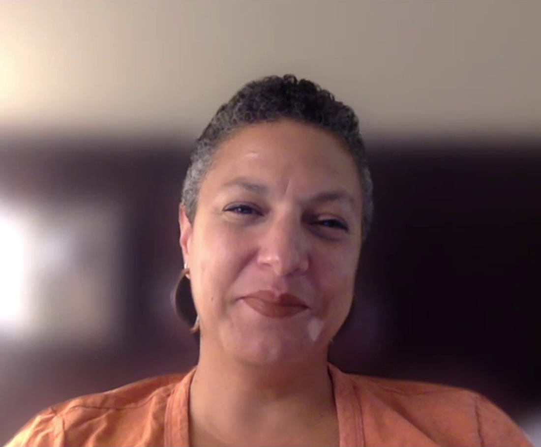 一件微笑的黑人妇女穿着橙色衬衫