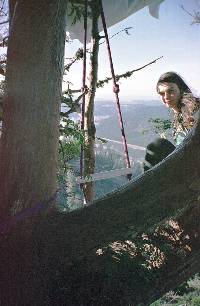 a woman sitting in a tree