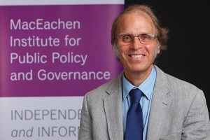 拉里·休斯身穿灰色夹克、浅蓝色衬衫和深蓝色领带的肖像