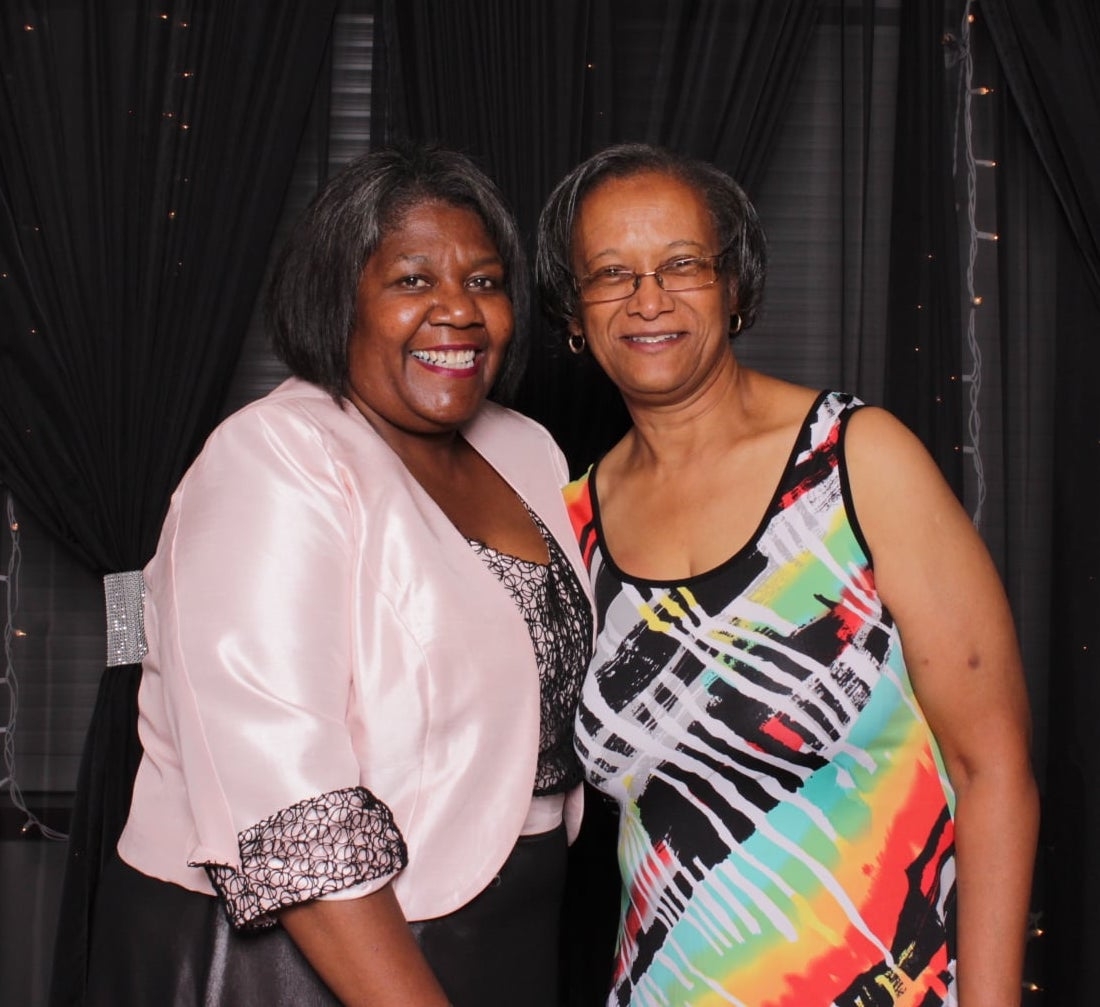 Two Black women smile together for the camera
