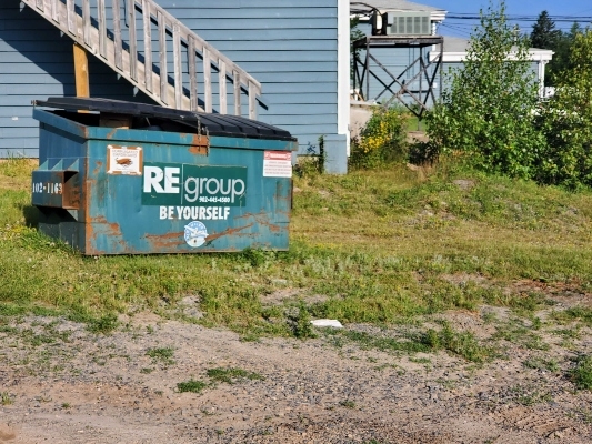 一个绿色的垃圾桶，上面写着“重组”公司的名字，还有一句话“做你自己”。