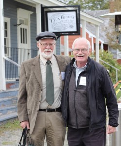 两位年长的绅士并肩站着，对着镜头微笑。