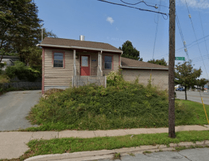 在两条街的拐角处有一座带院子的棕色小房子。