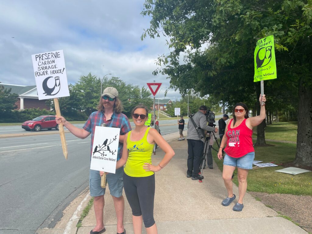 一群抗议者站在一栋大楼前的人行道上