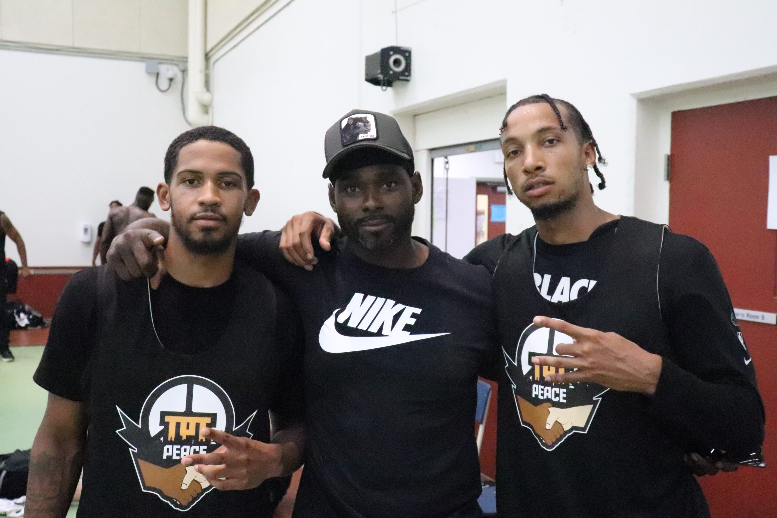 教练搂着两名篮球运动员摆姿势